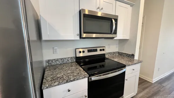 a kitchen with stainless steel appliances granite countertop a stove and a microwave