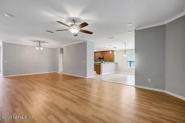 a view of an empty room and window and wooden floor