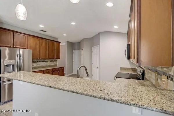 a kitchen with stainless steel appliances granite countertop a stove microwave and sink