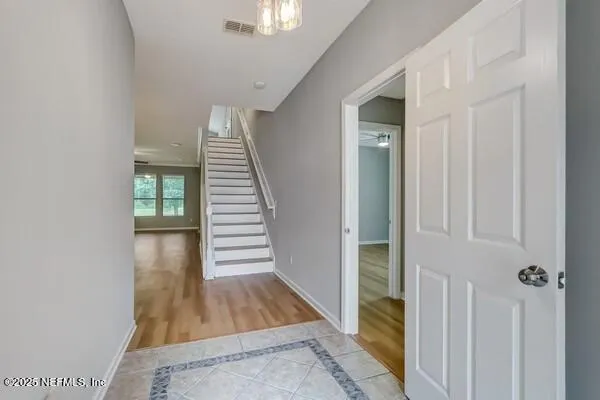 a view of a hallway with wooden floor and a front door