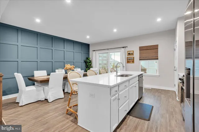 a kitchen with a sink and wooden floor
