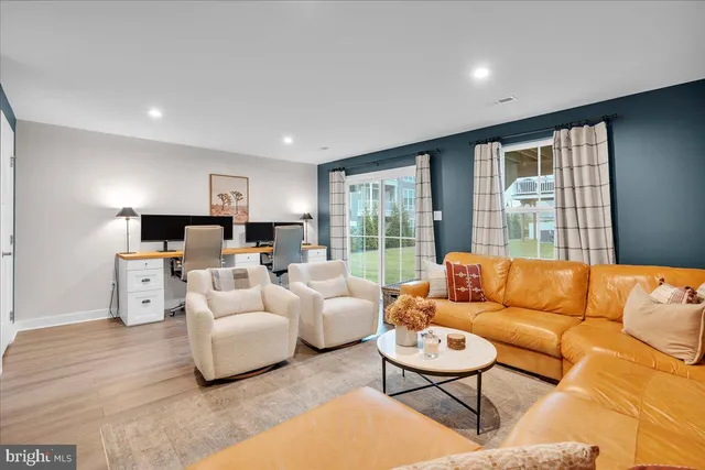 a living room with furniture flat screen tv and a large window