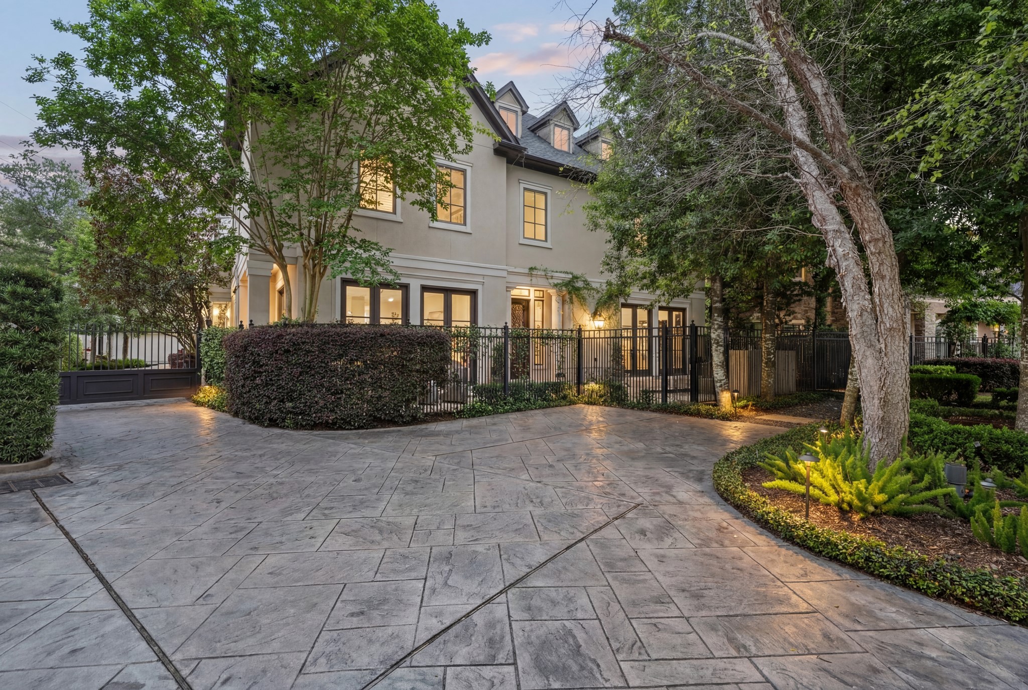 30 Hackberry Lane, Unit A Houston, TX 77027 - Photo 1 of 42 Gracious streetscape view of the gated freestanding garden home, showcasing classic architecture, manicured landscaping, mature trees, and refined exterior lighting that enhances privacy, security, and lock-and-leave appeal in the Mid Lane area.