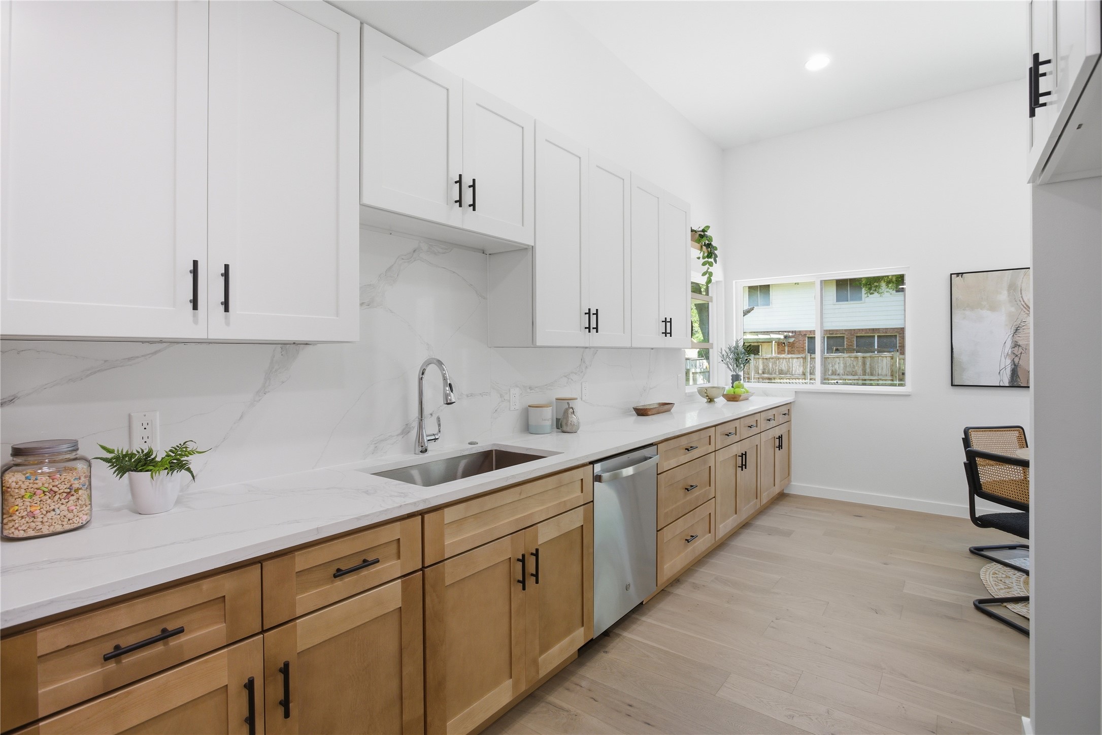 2110 Magazine Street Austin, TX 78727 - Photo 13 of 31 Spacious kitchen with extensive cabinet storage, white upper cabinets and natural wood-finish lower cabinets, complemented by white countertops and a matching backsplash