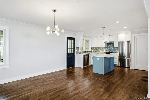a view of kitchen with granite countertop cabinets and refrigerator