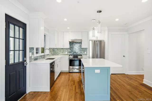 a kitchen with stainless steel appliances granite countertop a refrigerator a stove and a sink