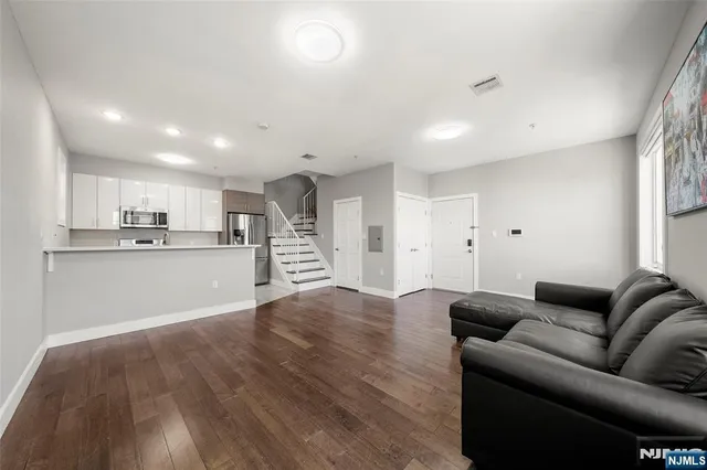a living room with furniture and kitchen view
