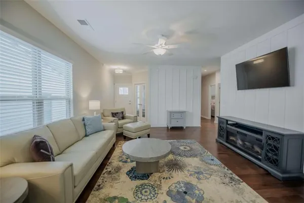 a living room with furniture a flat screen tv and a window