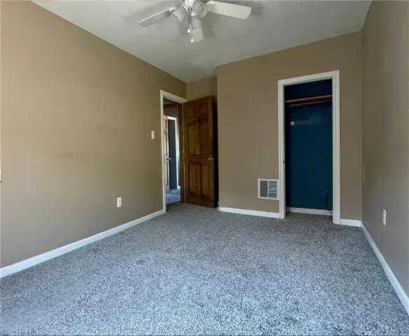 a view of an empty room with a chandelier fan