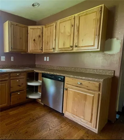 a kitchen with stainless steel appliances granite countertop a sink and cabinets with wooden floor
