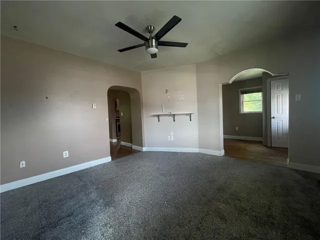 an empty room with closet and a ceiling fan