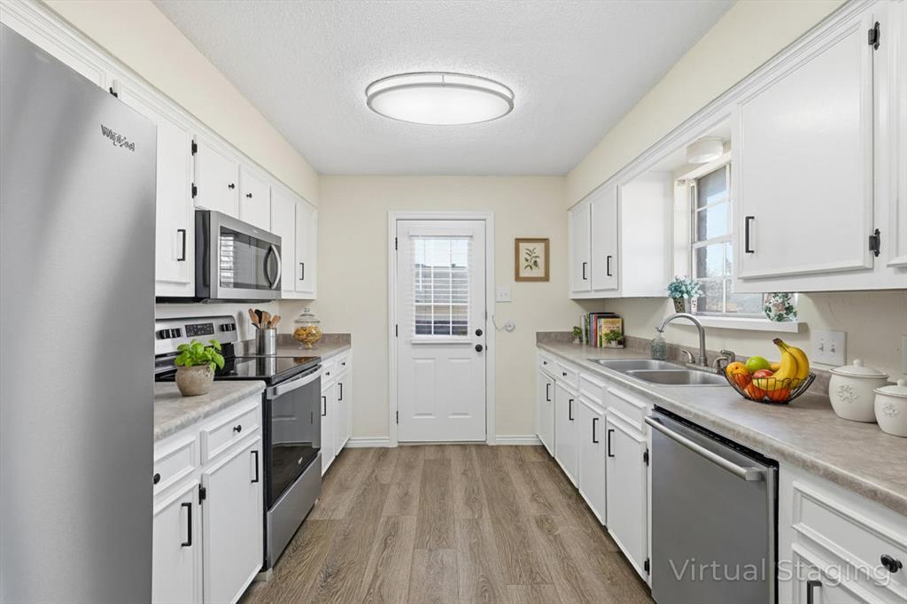 2145 Willow Place, Unit B Carrollton, TX 75006 - Photo 14 of 39 a kitchen with a sink a stove and cabinets