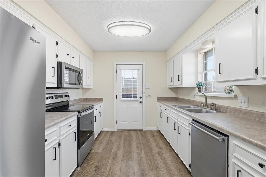 2145 Willow Place, Unit B Carrollton, TX 75006 - Photo 15 of 39 a kitchen with granite countertop a sink stove and cabinets
