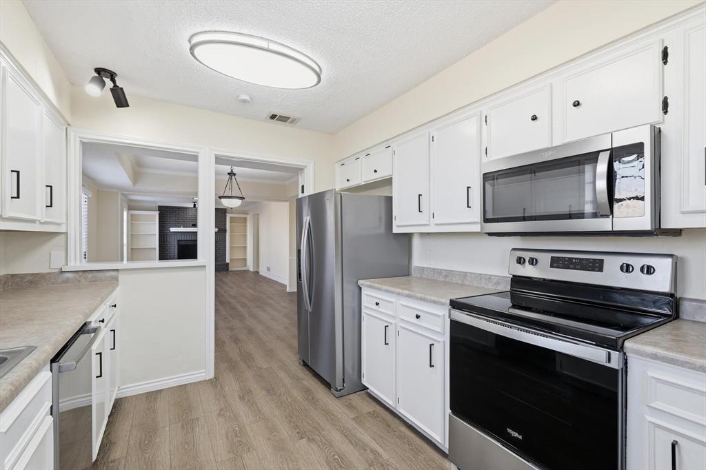 2145 Willow Place, Unit B Carrollton, TX 75006 - Photo 16 of 39 a kitchen with stainless steel appliances a stove microwave and sink