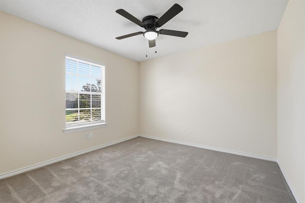 2145 Willow Place, Unit B Carrollton, TX 75006 - Photo 28 of 39 an empty room with a window and a ceiling fan