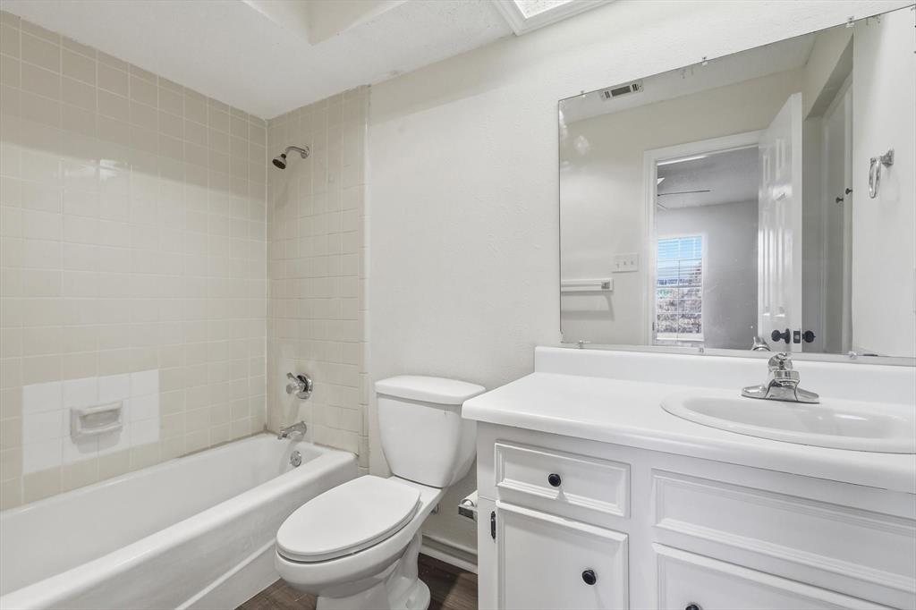 2145 Willow Place, Unit B Carrollton, TX 75006 - Photo 29 of 39 a bathroom with a sink a toilet and a mirror