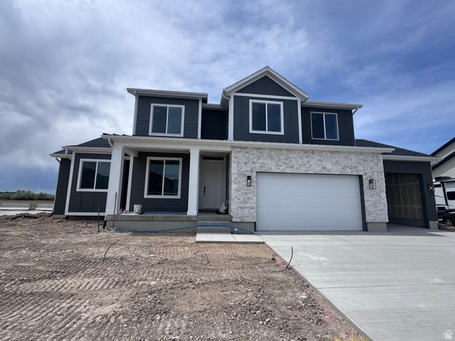1171 1475 East, Unit 82 Payson, UT 84651 - Photo 1 of 1 Modern two-story residence featuring dark siding, white stone accents, a two-car garage, an additional single-car garage, and a covered front entry with white columns
