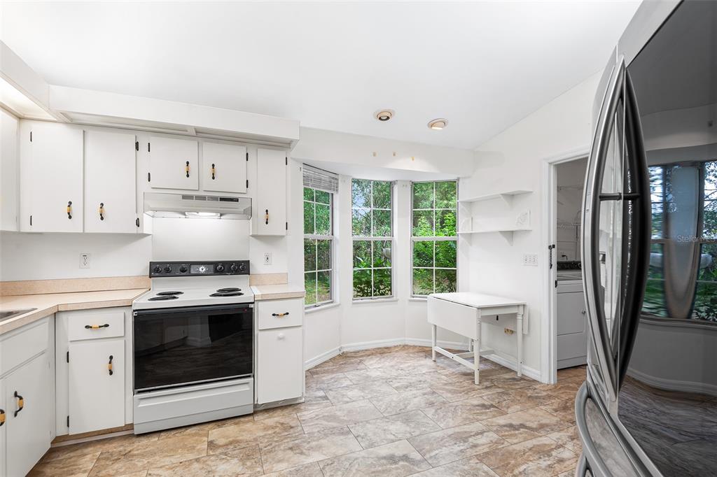 8297 Southwest 108th Loop Ocala, FL 34481 - Photo 5 of 14 a kitchen with stainless steel appliances granite countertop a stove a refrigerator and a sink with granite countertops