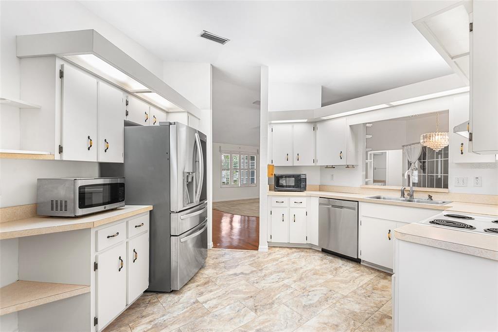 8297 Southwest 108th Loop Ocala, FL 34481 - Photo 7 of 14 a kitchen with white cabinets and white appliances