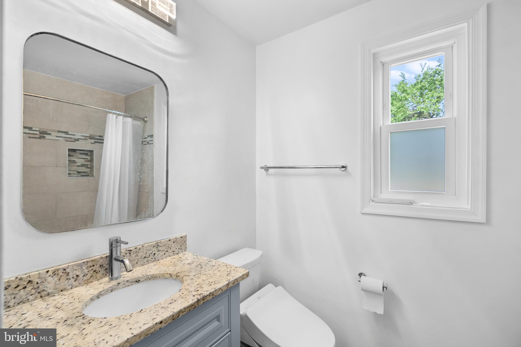 7402 Dunston Street Springfield, VA 22151 - Photo 21 of 37 a bathroom with a granite countertop sink toilet and mirror