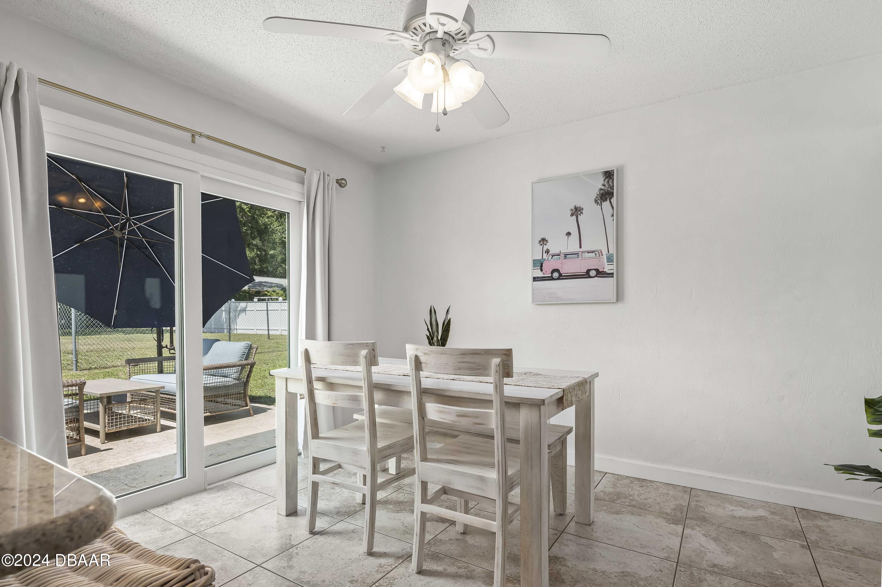 5528 Riverside Drive Port Orange, FL 32127 - Photo 12 of 31 a dining room with furniture a chandelier and a rug