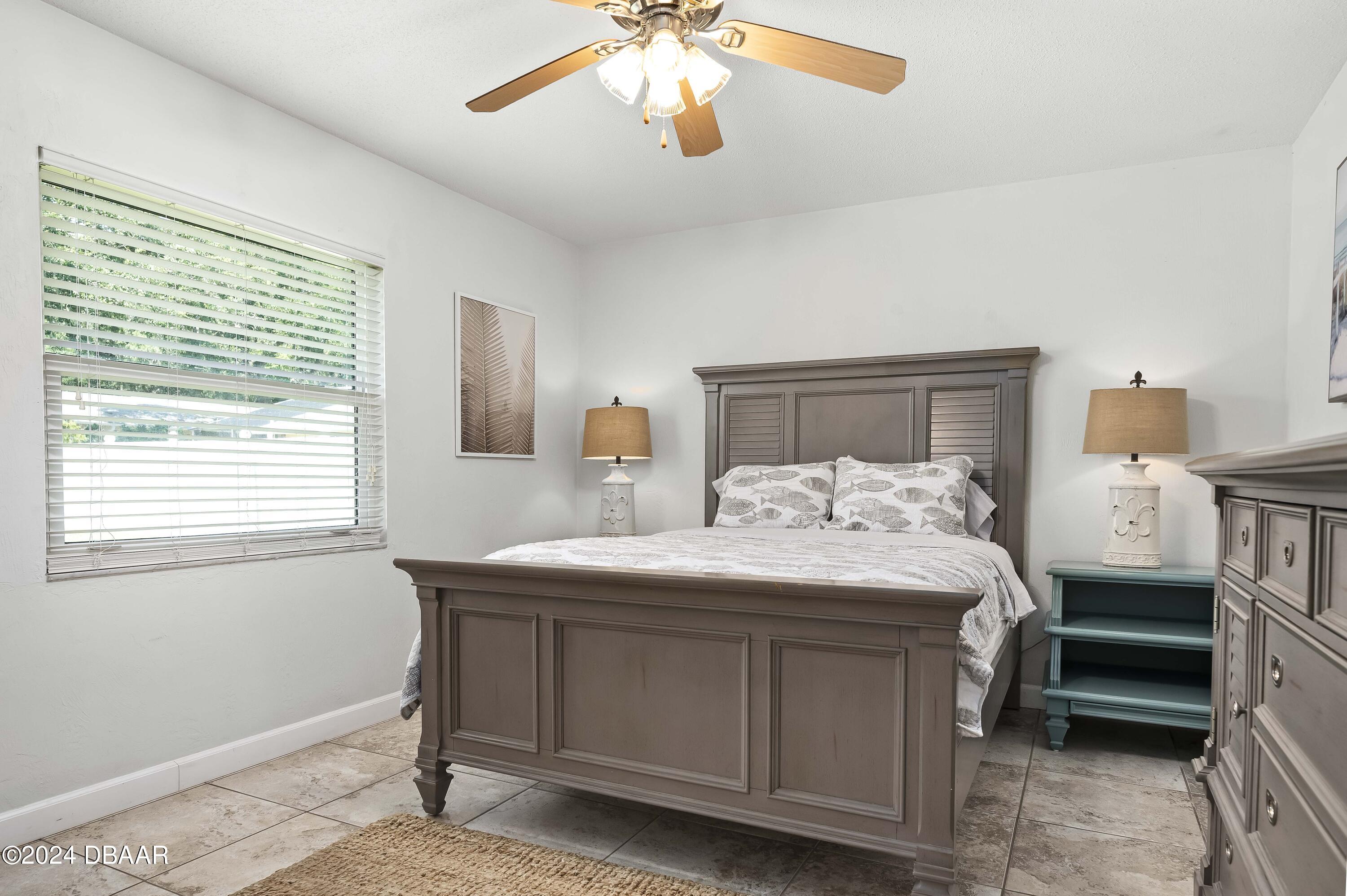 5528 Riverside Drive Port Orange, FL 32127 - Photo 16 of 31 a bedroom with a bed and a chandelier