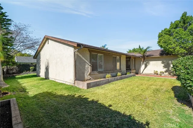 a view of a house with backyard and sitting area
