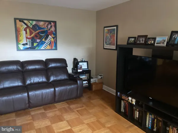 a living room with furniture and painting on the wall
