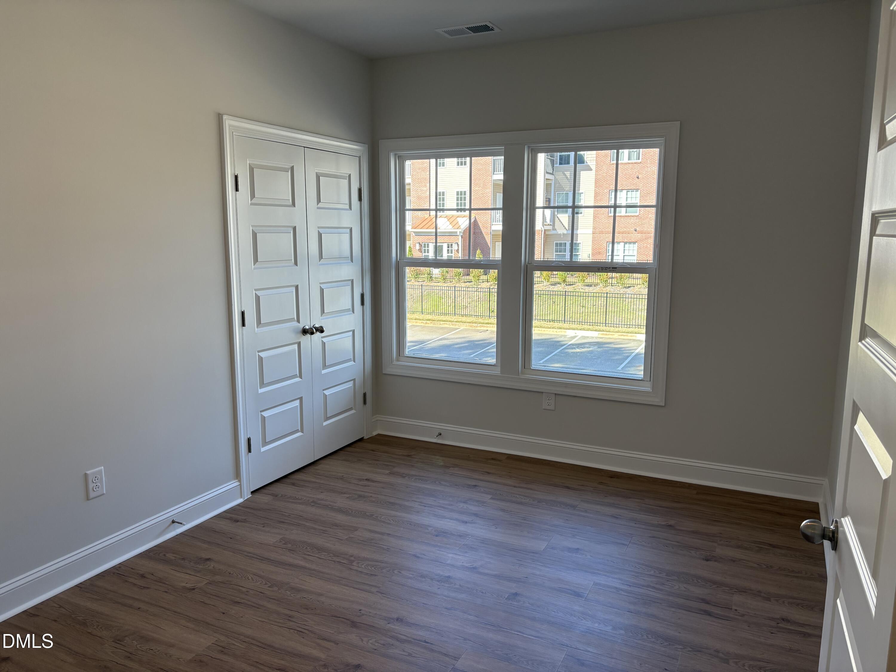 628 Weather Ridge Lane, Unit 36 Cary, NC 27513 - Photo 16 of 21 an empty room with wooden floor and windows
