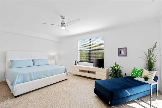 a bedroom with a large bed and a potted plant