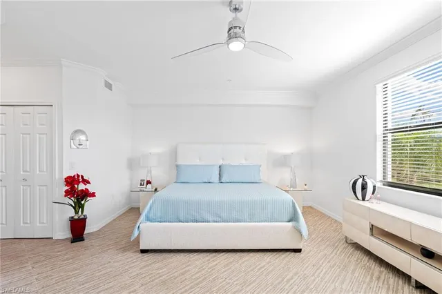 a bedroom with a bed and a potted plant