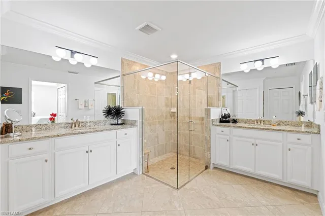 a bathroom with a granite countertop sink two mirror and a shower