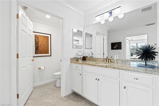 a bathroom with a granite countertop sink mirror and toilet