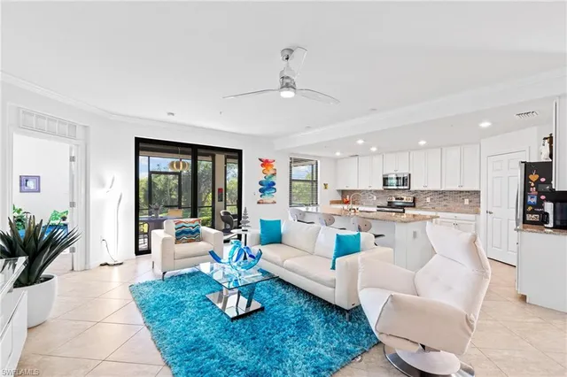 a living room with furniture kitchen view and a potted plant