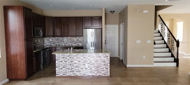 a view of entryway with kitchen and wooden cabinets