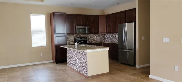 a kitchen with stainless steel appliances granite countertop a refrigerator stove and sink