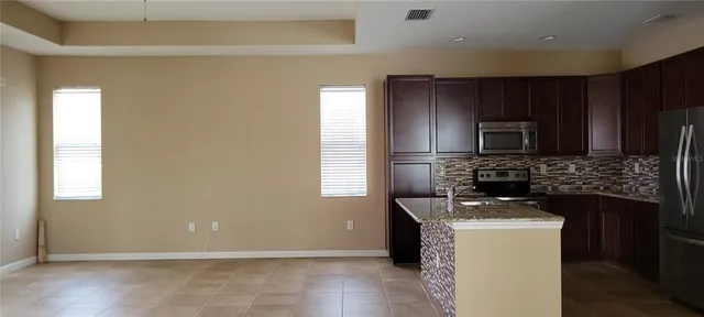 a kitchen with sink a microwave a refrigerator and cabinets