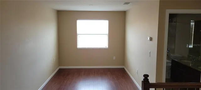 an empty room with wooden floor and a window