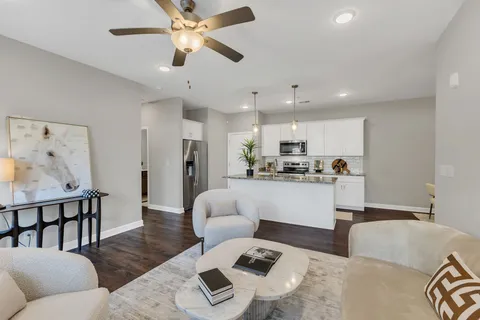 a living room with furniture and kitchen view