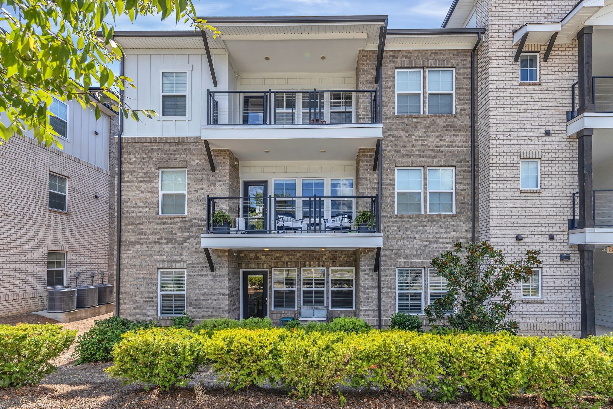 7487 Highway 70 South, Unit 101 Nashville, TN 37221 - Photo 19 of 20 a view of a building with brick walls and a large tree