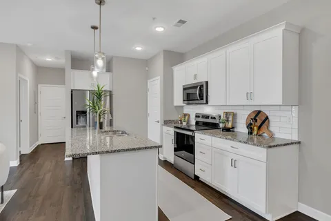 a kitchen with stainless steel appliances granite countertop a sink a stove and a refrigerator