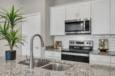 a kitchen with sink a microwave and stove