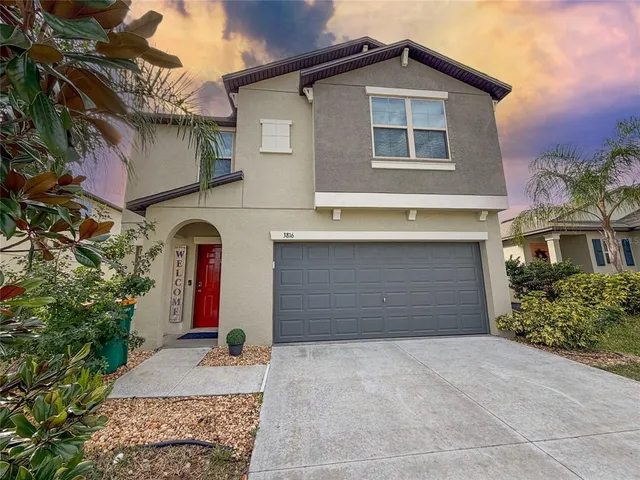 a front view of a house with a yard and garage
