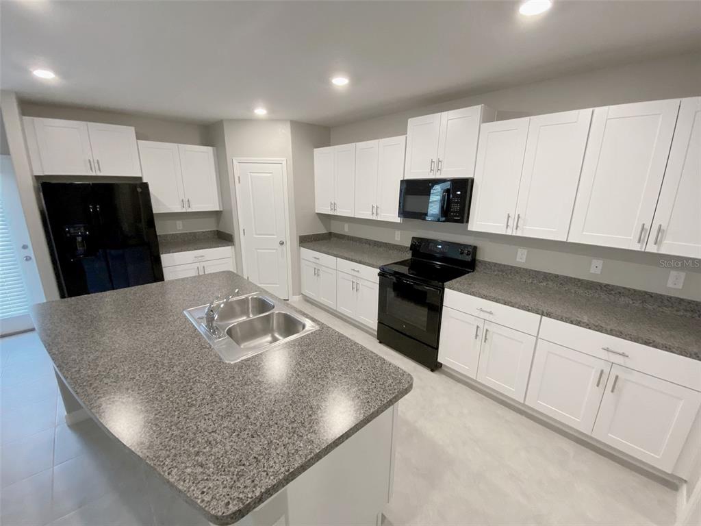 3816 Hanover Drive New Port Richey, FL 34653 - Photo 20 of 64 a kitchen with stainless steel appliances granite countertop a sink a stove and a refrigerator