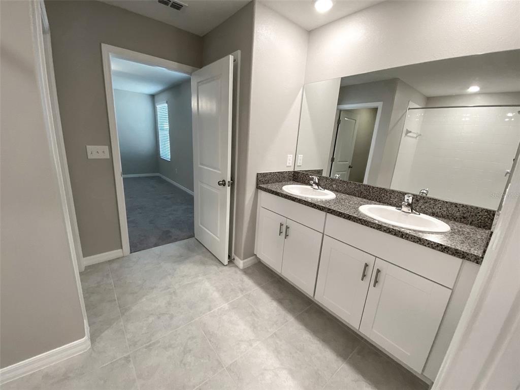 3816 Hanover Drive New Port Richey, FL 34653 - Photo 28 of 64 a spacious bathroom with a granite countertop sink a mirror and a