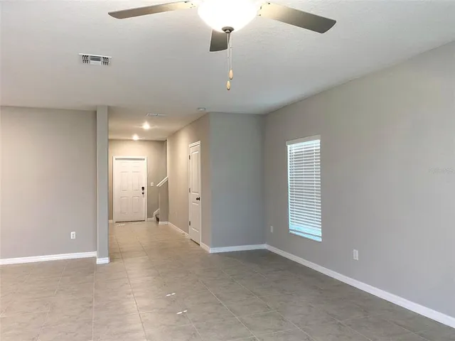 an empty room with windows and cabinet