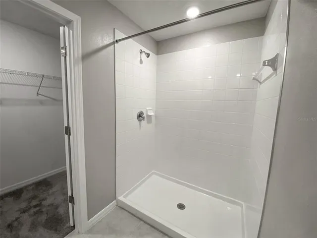 an empty room with closet and a chandelier fan