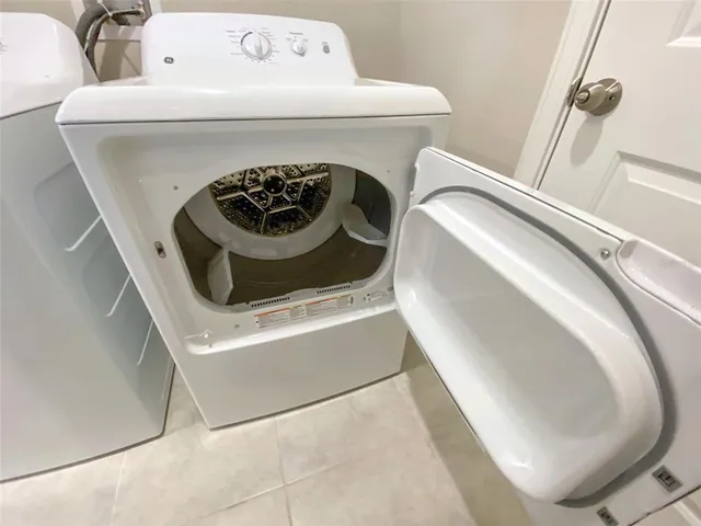 an empty room with windows and chandelier fan