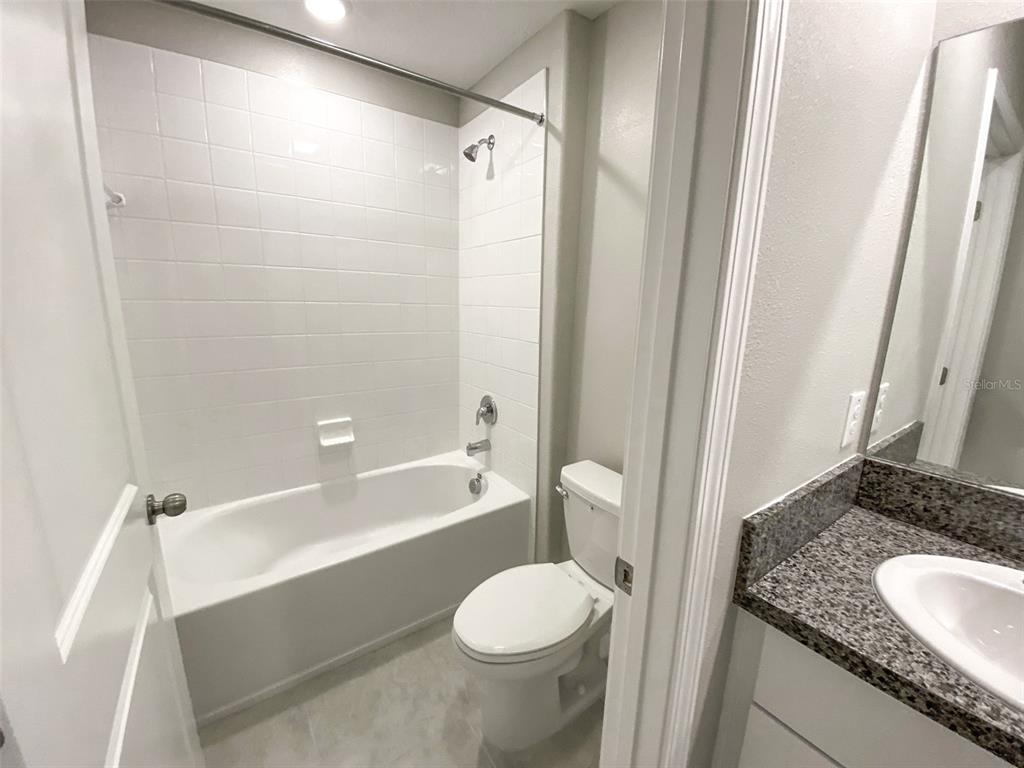 3816 Hanover Drive New Port Richey, FL 34653 - Photo 42 of 64 a bathroom with a granite countertop toilet and a sink