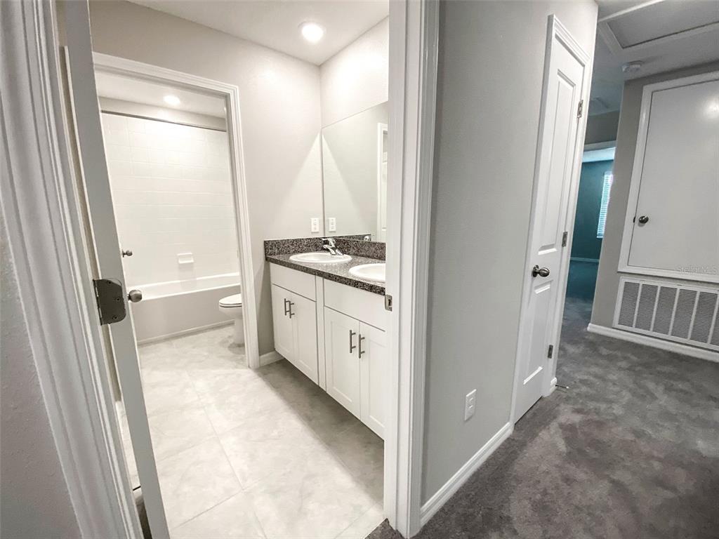 3816 Hanover Drive New Port Richey, FL 34653 - Photo 44 of 64 a bathroom with a granite countertop sink a mirror and a bathtub